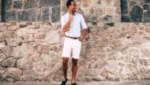 Men's summer capsule wardrobe with linen shirts, shorts, sneakers, and warm neutral colors