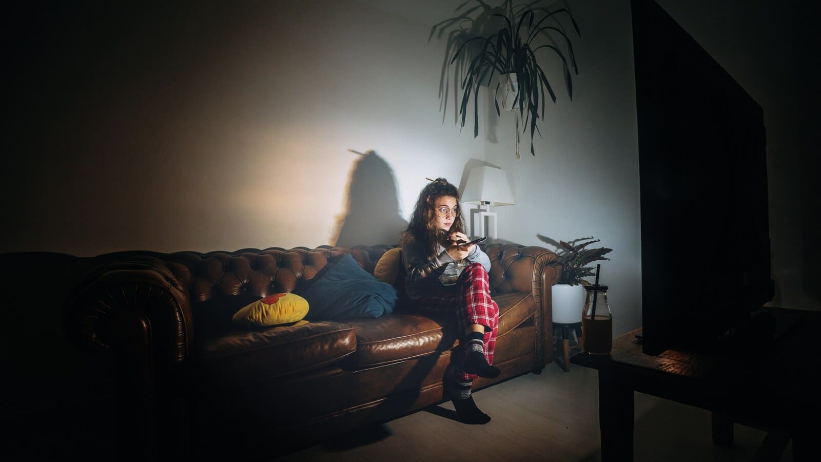 Person watching a scary video on a laptop in a dark room