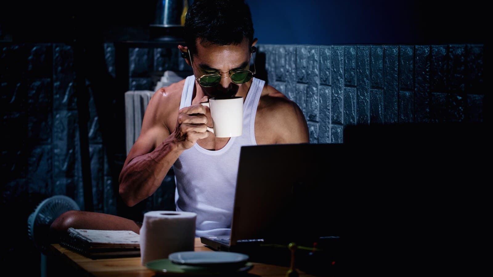 Person watching a scary movie on a laptop in a dark room