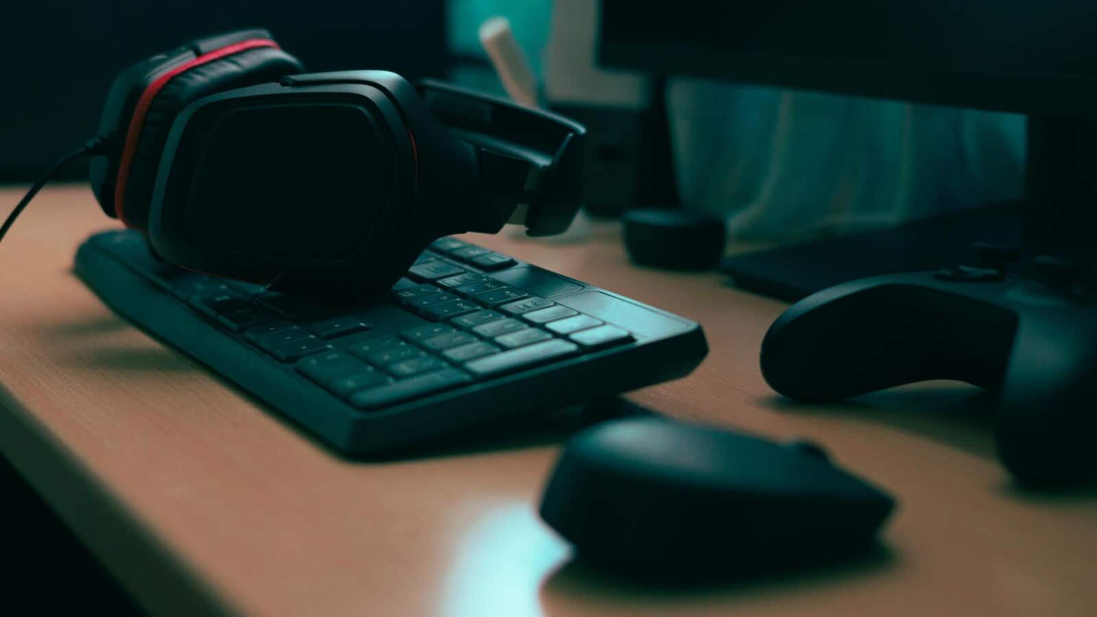 Dark gaming desk with headphones and keyboard during a tense night session